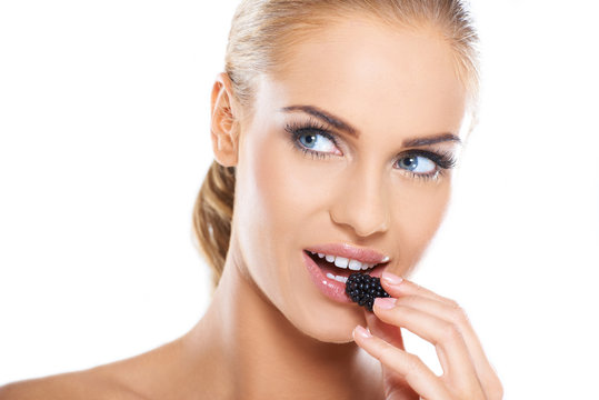 Close up of beautiful woman eating blackberries