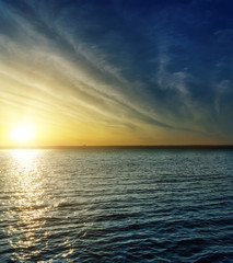 Fototapeta na wymiar cloudy sunset over water