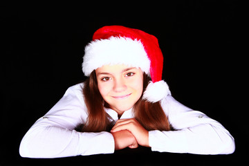smiling girl in christmas hat over dark