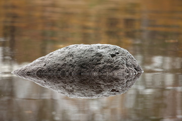 the black meteorite is reflected in water