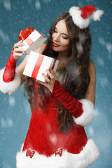 Beautiful  girl wearing santa claus clothes with christmas gift 
