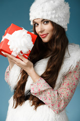 Beautiful girl with christmas gift in hand. Holidays concept