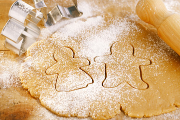 gingerbread boy and girl cokkies cutters on rolling dough