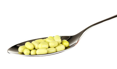 colorful pills on spoon on white background close-up