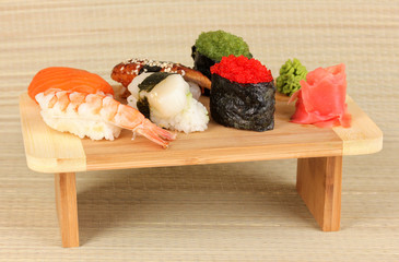 delicious sushi served on wooden board on bamboo mat