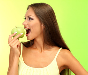 beautiful young woman with green apple, on green background