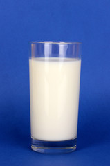 Glass of fresh new milk on blue background