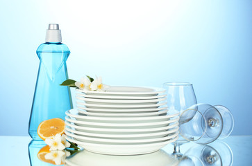 empty clean plates and glasses with dishwashing liquid, sponges