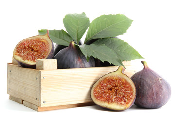 Ripe sweet figs with leaves in wooden crate isolated on white