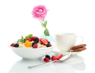 tasty oatmeal with berries and cup of tea, isolated on white