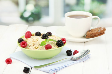 tasty oatmeal with berries and cup of tea