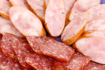 Tasty sliced sausage on plate close-up