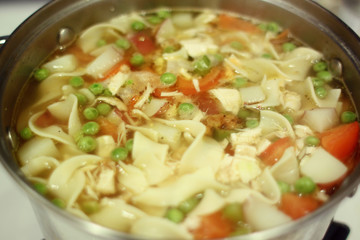 Homemade chicken noodle soup on the stove.