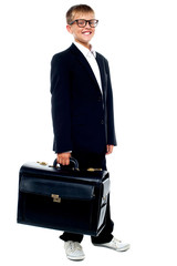 Full length portrait of cute boy carrying a briefcase