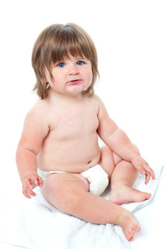 Cute baby girl sitting up wearing a diaper
