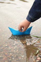 paper ship in children hand