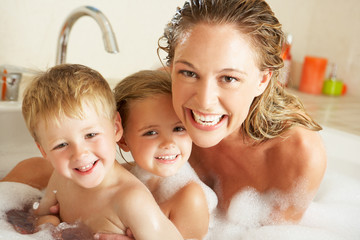 Mother With Children Relaxing In Bubble Filled Bath