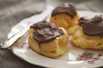 Profiteroles eclairs on a vintage plate