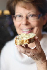 Senior woman eating a slice of toast