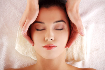 Woman enjoy receiving face massage at spa saloon