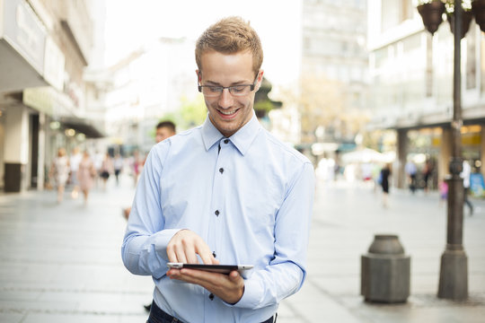 Happy Smiling Businessman With Tablet Computer in public space