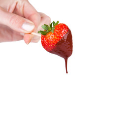 Strawberry dipped in melting dark chocolate with woman hand 