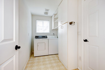 Laundry room with white walls and appliances.