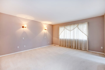 Large beige bedroom with lights and curtains.