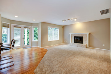 Large bright empty new living room with fireplace.