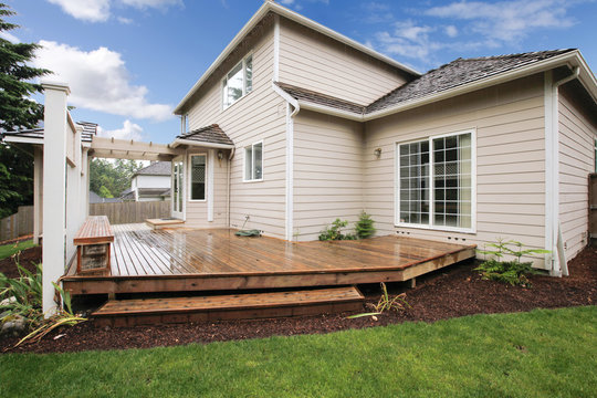 Large Beige House With Porch From The Backyard.