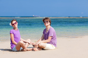 beautiful young couple sitting and having fun on beach