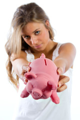 Saving, blonde young woman with a  piggy bank