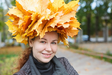 Attractive woman in autumn park with yellow maple