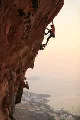 Fotobehang Rock climber at sunset, Kalymnos Island, Greece © Andrey Bandurenko