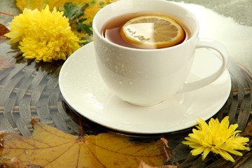 cup of hot drink and autumn leaves, close up