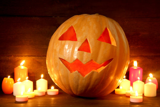 halloween pumpkin and candles, on wooden background