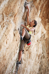 Young female rock climber on a cliff face
