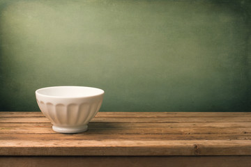 Grunge background with white bowl on wooden table