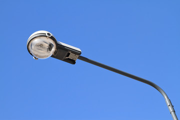 Street light with halogen lamp against blue sky