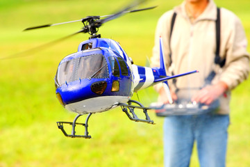 Piloting Radio controlled helicopter with remote control. © Kletr