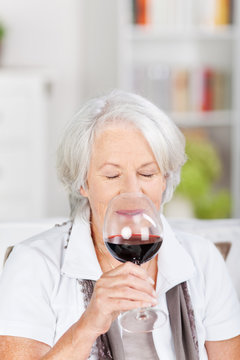 seniorin genießt ein glas rotwein