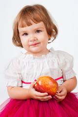 The little girl with an apple, on a gray background