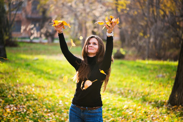 young woman throwing leaves woman in the forest