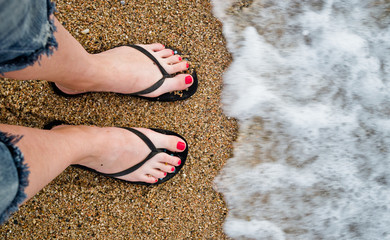 slim girl's legs on sandy beach