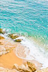 The waves breaking on a stony with day light