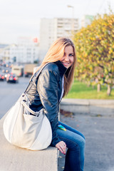 Fototapeta premium Young woman sitting at the railing.