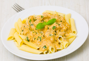 Penne pasta with chicken meat, cream sauce and basil