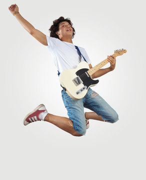 Young Man Playing On Electro Guitar And Jumping