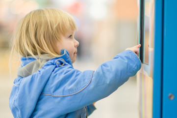 Adorable girl eat chocolate and play with information terminal i