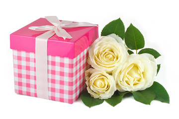 Gift box with a bow and a bouquet of delicate roses